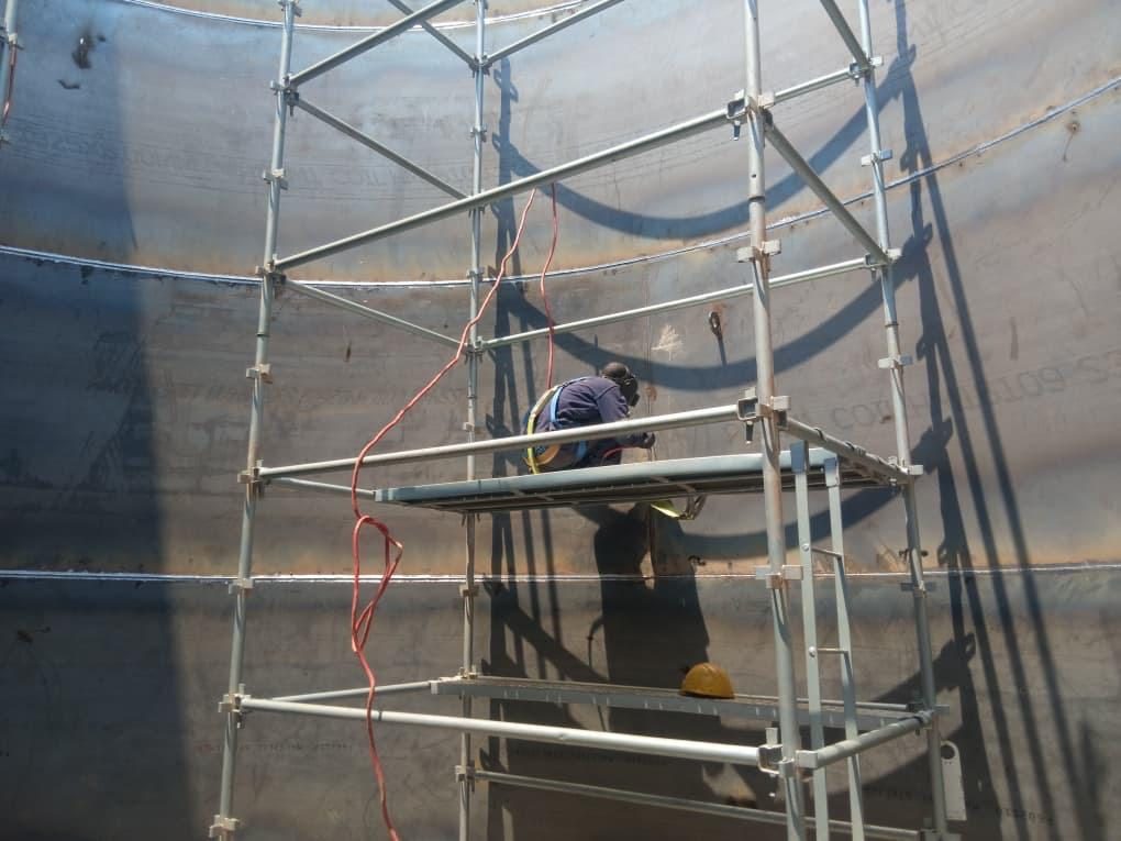 Welding works on scaffolding inside a tank